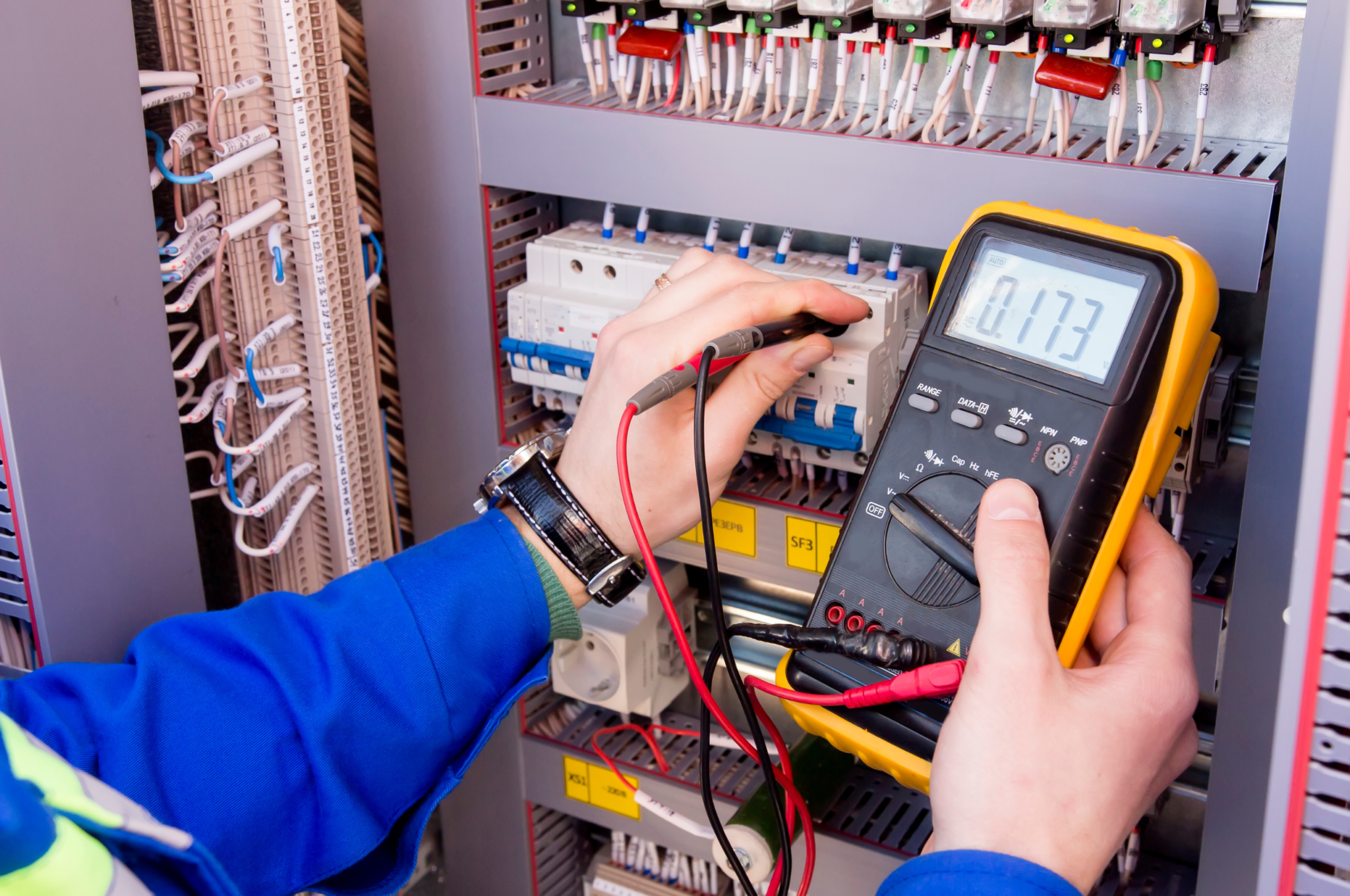 Electrician testing an electrical switchboard while completing trade work